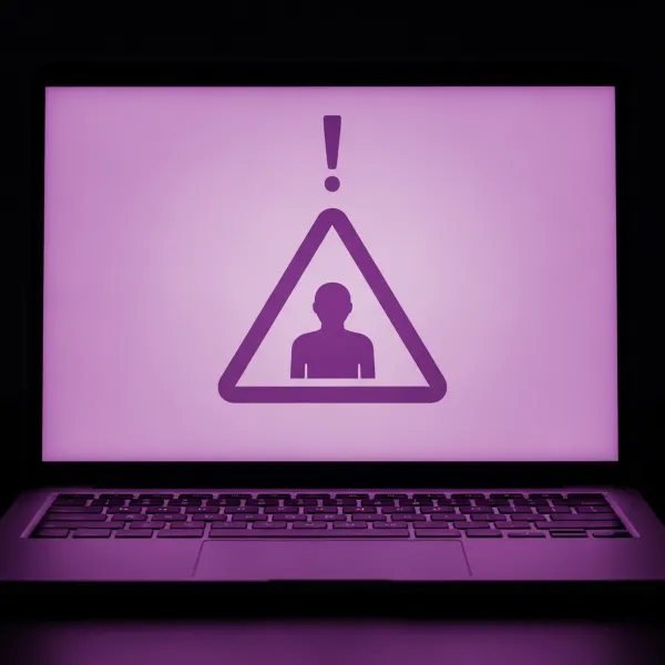 Laptop con alerta de usuario, señal de que debes saber cómo limpiar tu hosting si tienes malware o virus.